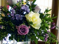 Table Arrangement in a Tall Glass Vase filled with an Arrangement of Roses, Freesias and Phlox with seasonal Foliages